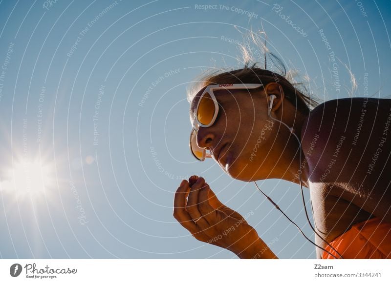 Trauben essen am Strand gardasee pause trauben strand erholung musik hören kopfhörer sonnebrille blond mädchen frau jung hipp schön bikini sommer blauer himmel