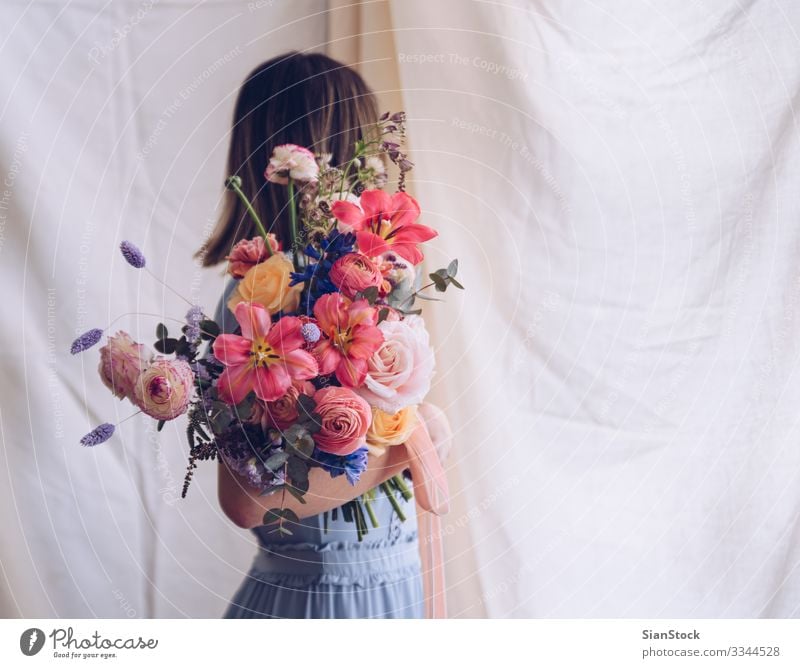 Junge Frau in einem hellblauen Kleid mit einem Blumenstrauß in der Hand. Lifestyle elegant Stil Glück schön Hochzeit Erwachsene brünett modern niedlich retro