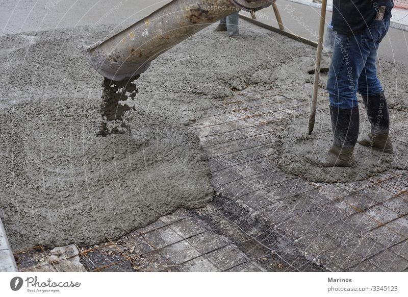 Arbeiter, die nassen Beton mit Hilfe eines Betonkübels gießen. Arbeit & Erwerbstätigkeit Baustelle Industrie Business Gebäude Straße Stahl bauen Zementmischung