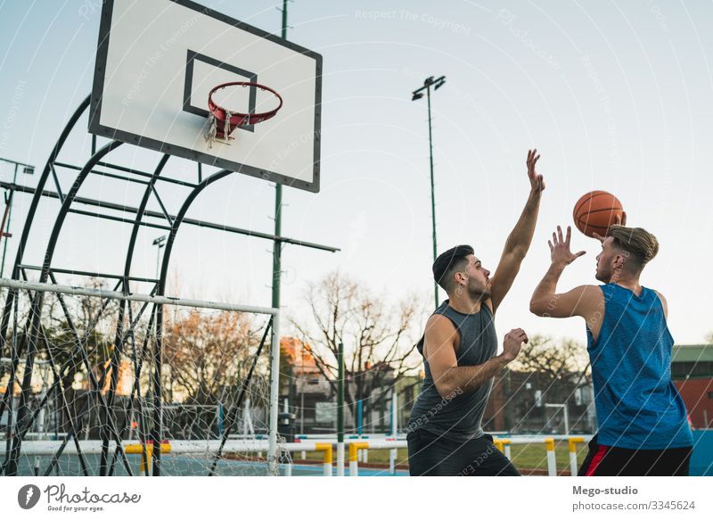 Junge Basketballspieler im Einzelspiel. Freude Glück Erholung Freizeit & Hobby Spielen Sport Ball Mensch maskulin Mann Erwachsene Freundschaft 2 Menschengruppe