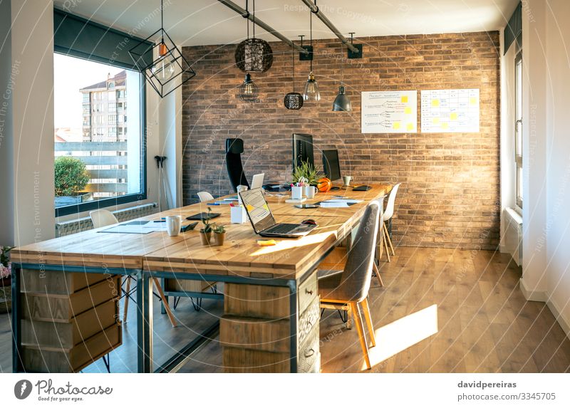 Interieur eines Coworking-Büros im Industriestil Design Dekoration & Verzierung Lampe Schreibtisch Stuhl Tisch Arbeitsplatz Business Computer Notebook Pflanze