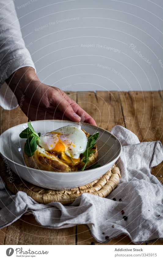 Tisch mit Zutaten zum Kochen und offener Kartoffel mit Ei Lebensmittel Essen zubereiten Prozess hölzern gebraten Kraut Käse Gewürz Erdöl Hand Messer Schneiden