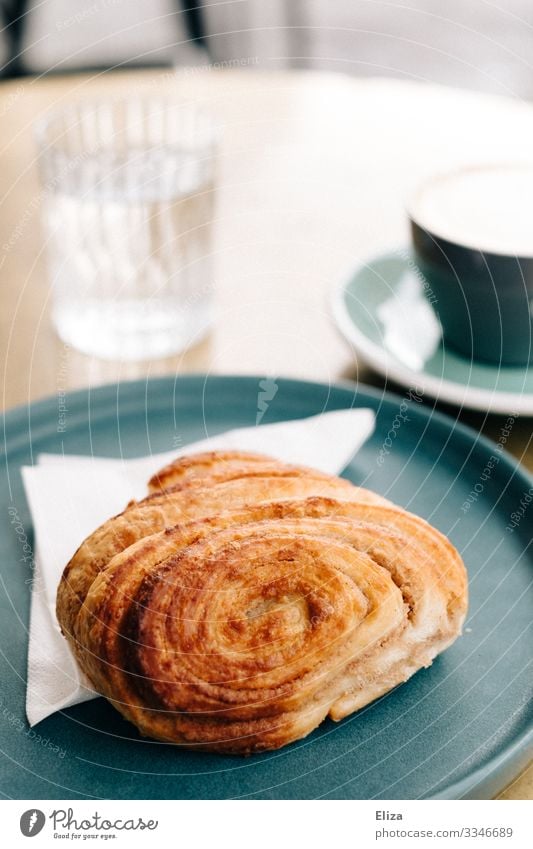 Lecker Franzbrötchen Frühstück Kaffeetrinken lecker Café Dessert Backwaren franzbrötchen süß Süßwaren Kaffeepause Tisch Wasserglas Teller genießen Farbfoto