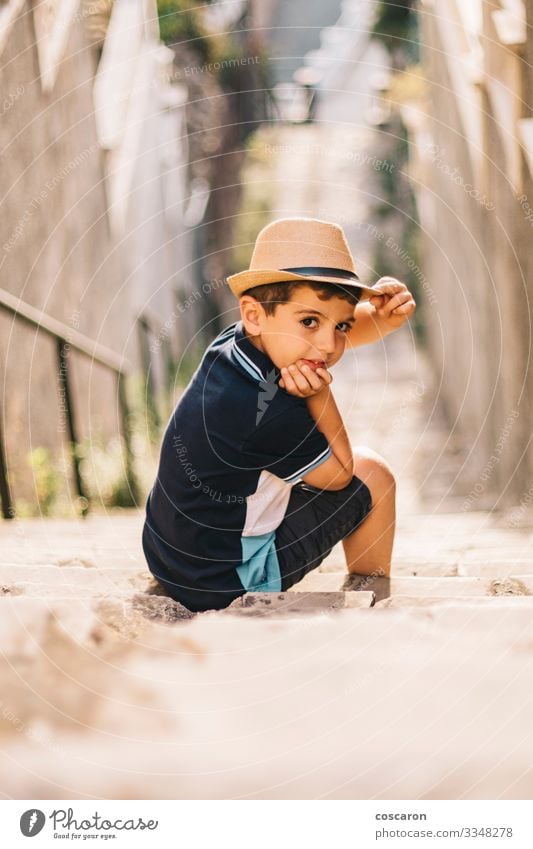 Porträt eines süßen Jungen mit Hut auf einer Treppe Lifestyle Stil Freude Glück schön Sommer Sommerurlaub Sonne Kind Fotokamera Mensch Kleinkind Kindheit 1