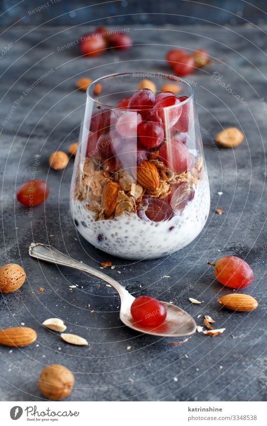 Chia-Puddingparfait mit roten Trauben und Mandeln Joghurt Frucht Dessert Essen Frühstück Diät Löffel dunkel grau weiß Glas Parfait Weintrauben rote Weintrauben