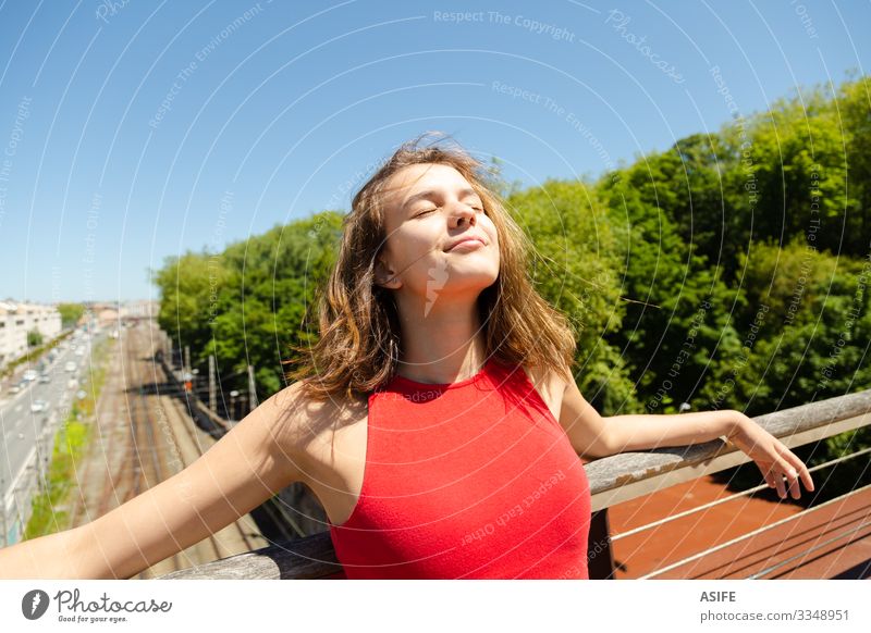 Junge schöne Frau beim Sonnenbaden auf einer Brücke über die Stadt Lifestyle Freude Glück Erholung Freizeit & Hobby Sommer Erwachsene Jugendliche Natur Wind