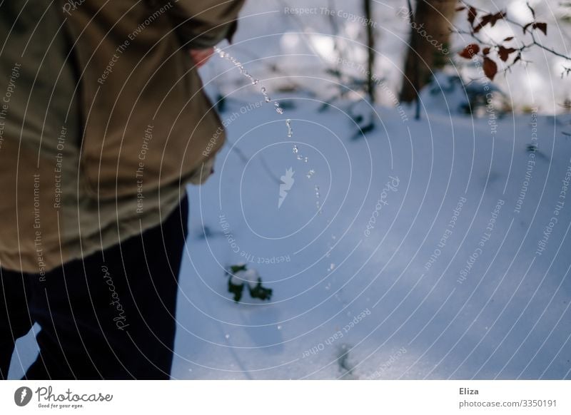 Ein Mann pinkelt in den Schnee pinkeln urinieren Wildpinkeln Pipi Strahl Urin Wasser lassen draußen Natur Wald Winter kalt