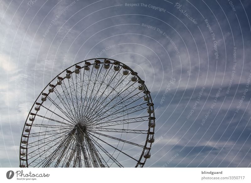 Ein Riesenrad vor bewölktem, dunklem Himmel an der Promenade von Oostende, an der belgischen Nordseeküste. Jahrmarkt Feste & Feiern Freude Außenaufnahme