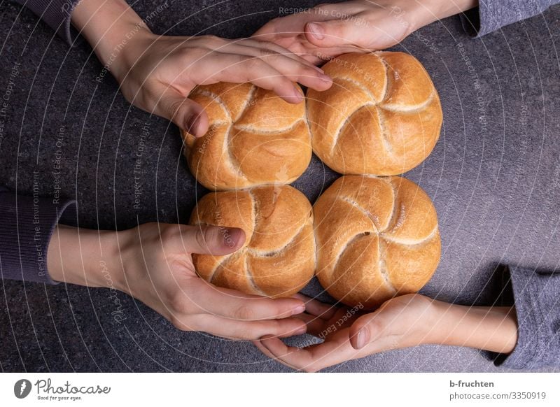 Vier Semmeln mit Kinderhänden Lebensmittel Teigwaren Backwaren Brot Brötchen Ernährung Essen Frühstück Büffet Brunch Bioprodukte Küche Kindheit Hand Finger