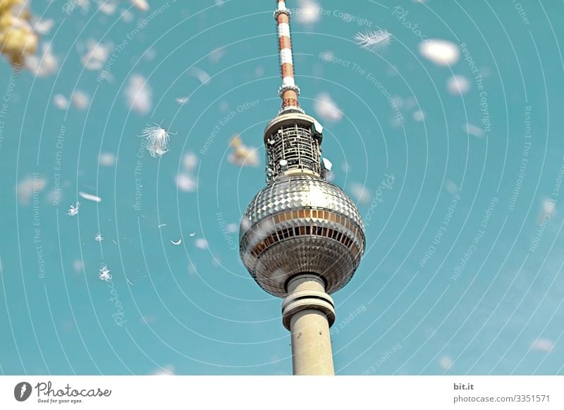 Weiße Federn von einem Flashmob mit Kissenschlacht, fallen vom Himmel, auf den Fernsehturm in Berlin, unter blauem Himmel im Frühling. Tag Hintergrund neutral