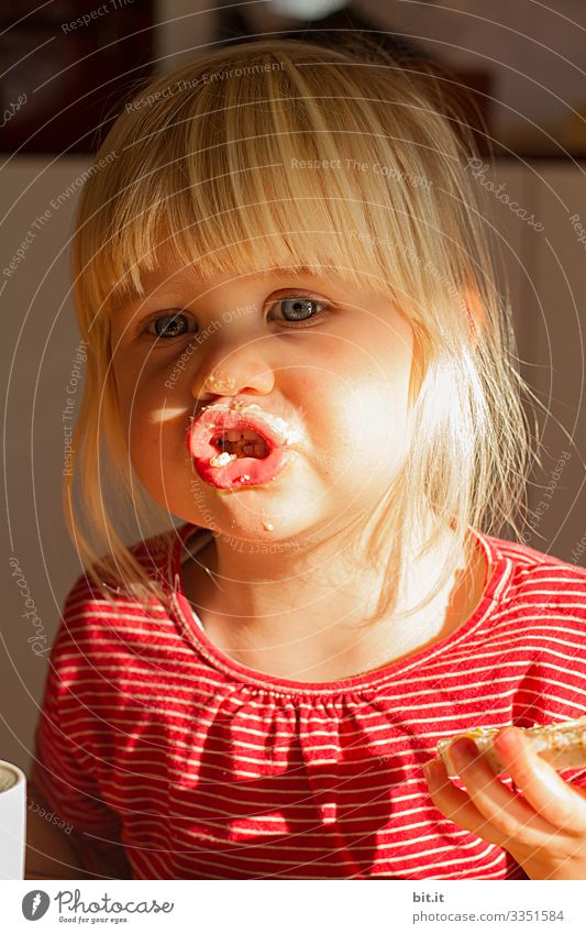 Zuerst die Butter, dann das Brot, erklärt das kleine Mädchen der Sonnenschein, mit verschmierten Mund. Kinderspiel Kindergarten kita Kindererziehung Erziehung