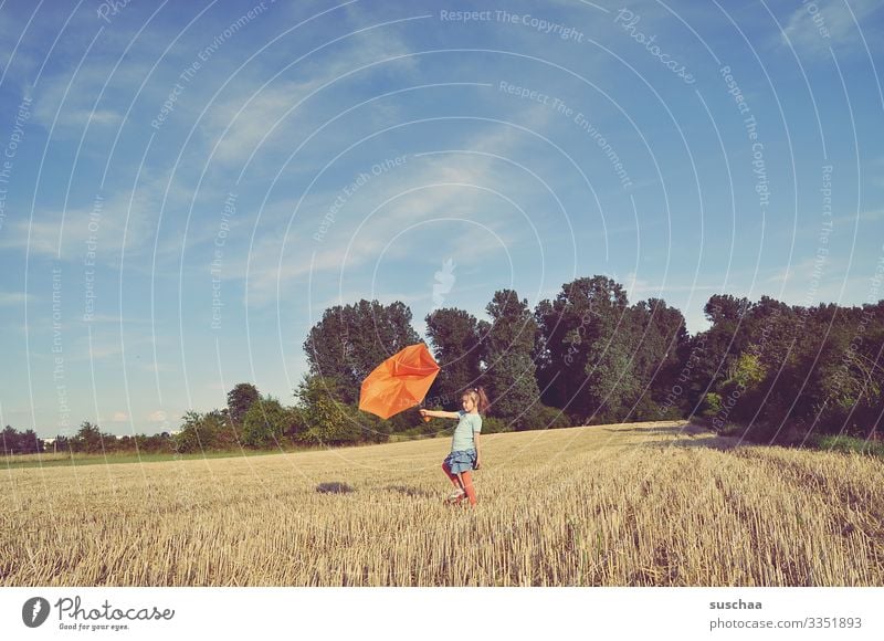 kind steht auf dem strohacker und hält einen kaputten regenschirm gegen den wind Kind Mädchen Acker Strohacker Getreidefeld Sommer Landschaft Natur Regenschirm