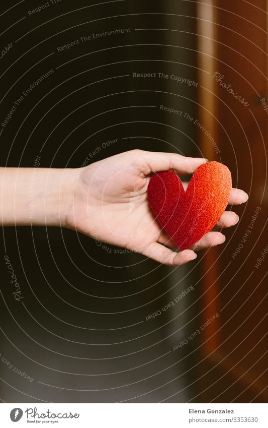 Junge Frau mit rotem Glitzerherzkarton in Herzform auf der Hand. Feste & Feiern Valentinstag Büroarbeit Mensch Erwachsene Jugendliche Liebe tragen Fröhlichkeit