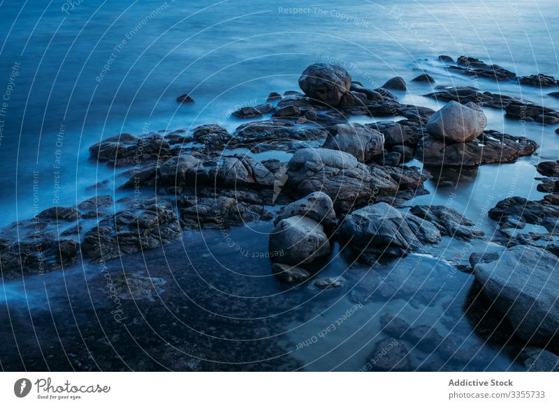 Dunkle Insel umgeben von schäumenden Wellen unter bewölktem Himmel Meer steinig Ufer MEER Wasser Küste Strand reisen Natur Felsen Landschaft Tourismus marin