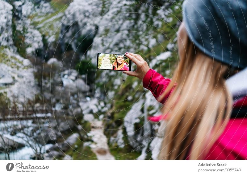 Frau mit Rucksack nimmt sich auf dem Smartphone auf dem Hintergrund der Berge mit Tourist Selfie Berge u. Gebirge benutzend reisen Natur Gerät Apparatur