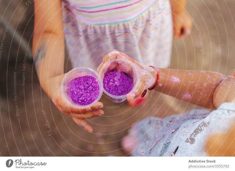 Kleine Mädchen zeigen Tassen mit Farbe im Park Stadtfest Sommer Zusammensein Freund Feier wenig Kind Saison Pigment Farbstoff Pulver manifestieren Feiertag