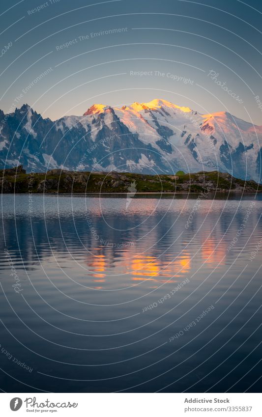 Gewogter See reflektiert orangefarbenen Himmel und Berge Berge u. Gebirge Landschaft verschneite Wasser Reflexion & Spiegelung leer Kristalle malerisch reisen