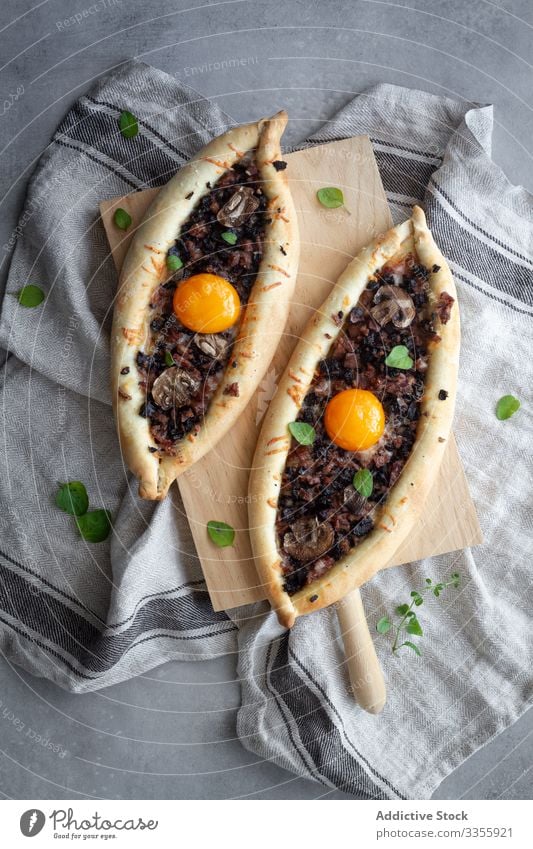 Frische appetitanregende kachapuri auf Holzständer auf Leinen bei Tisch Ei appetitlich geschmackvoll frisch Mahlzeit Speise Abendessen Lebensmittel Mittagessen