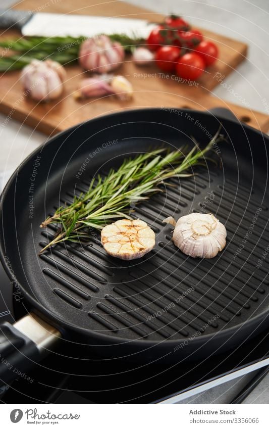 Grillpfanne mit Rosmarin und Knoblauch in der Küche Pfanne Grillrost Gewürz Kraut Essen zubereiten Lebensmittel aromatisch braten Mahlzeit Geschmack Bestandteil