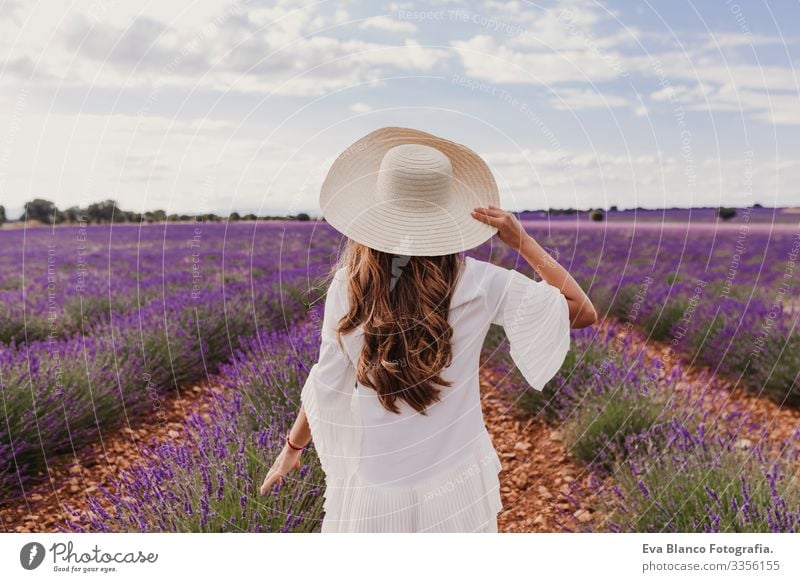 Charmante junge Frau mit Hut und weißem Kleid in einem lila Lavendelfeld bei Sonnenuntergang. LIfestyle im Freien. Rückansicht Wiese Beautyfotografie Freude