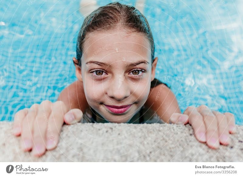 Ein wunderschöner Teenager schwebt in einem Pool und schaut in die Kamera. Spaß und sommerlicher Lebensstil Aktion Schwimmbad Beautyfotografie Außenaufnahme