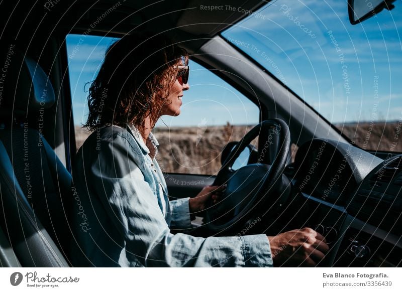 junge, schöne Frau am Steuer eines Autos. Reisekonzept Jugendliche fahren PKW Sonnenstrahlen Sonnenbrille Ferien & Urlaub & Reisen reisend Rad Laufwerk mieten