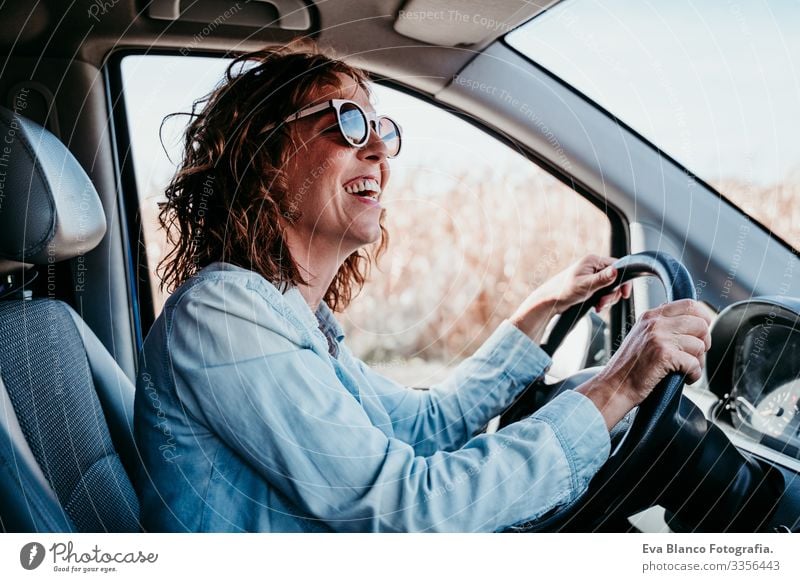 junge, schöne Frau am Steuer eines Autos. Reisekonzept Jugendliche fahren PKW Sonnenstrahlen Sonnenbrille Ferien & Urlaub & Reisen reisend Rad Laufwerk mieten