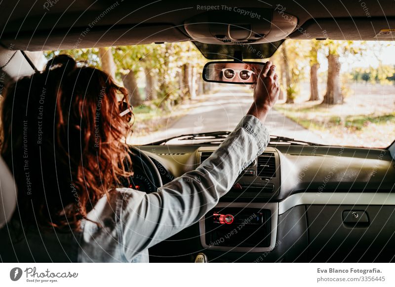 junge schöne frau beim autofahren. reisekonzept. ansicht von innen. weg der bäume straße Frau Jugendliche PKW Sonnenstrahlen Sonnenbrille