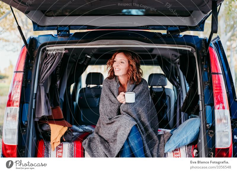 junge, schöne Frau, die mit einem Lieferwagen im Freien campen und Kaffee oder Tee trinken. Reisekonzept Teekanne Hund Border Collie Kleintransporter Van Leben