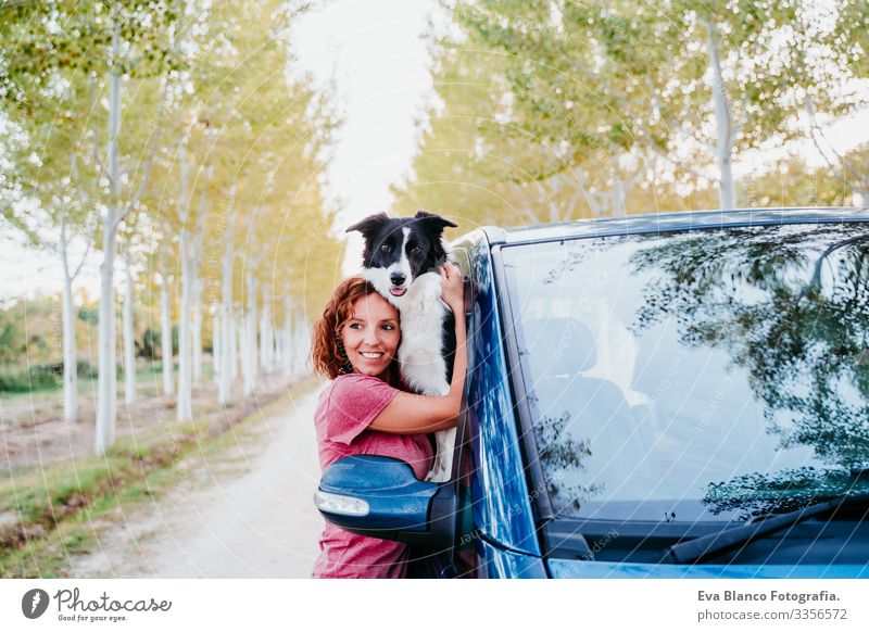 Frau, die ihren Border-Collie-Hund in einem Lieferwagen umarmt. Reisekonzept Border Collie Kleintransporter Van Leben Ferien & Urlaub & Reisen reisend Besitzer