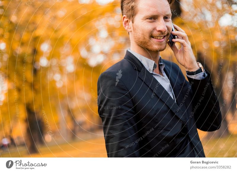 Junger Mann mit Handy im Herbstpark Lifestyle Stil sprechen Telefon PDA Technik & Technologie Mensch Jugendliche Erwachsene 1 18-30 Jahre Natur Park Wald