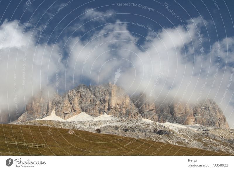 Berge der Alpen hüllen sich in dicke Wolken vor blauem Himmel Berge u. Gebirge Dolomiten Sellajoch Herbst Wiese wandern Bergsteigen Umwelt Natur Landschaft