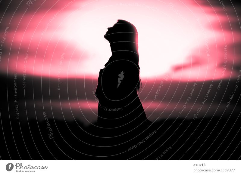 Jugend Frau Seele bei roter Sonne Meditation träumt vergangenen Zeiten. Silhouette vor Sonnenuntergang oder Sonnenaufgang in sommerlicher Natur. Symbol für Heilung Burnout Therapie, Wellness Entspannung oder Auferstehung.