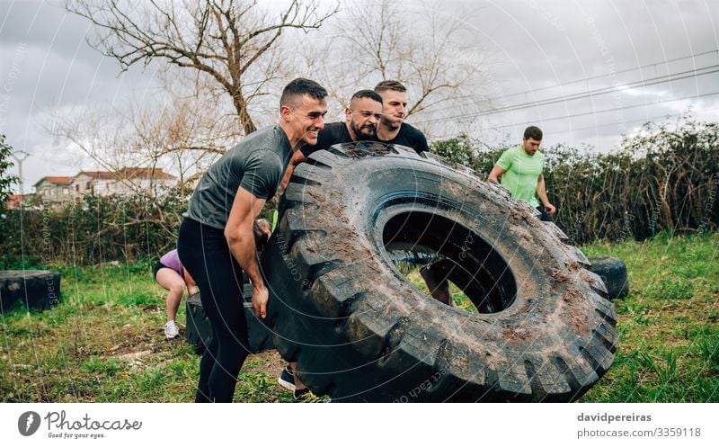 Teilnehmer im Hindernisparcours drehen LKW-Rad Sport Mensch Mann Erwachsene Menschengruppe authentisch stark schwarz Kraft anstrengen Konkurrenz Teamwork