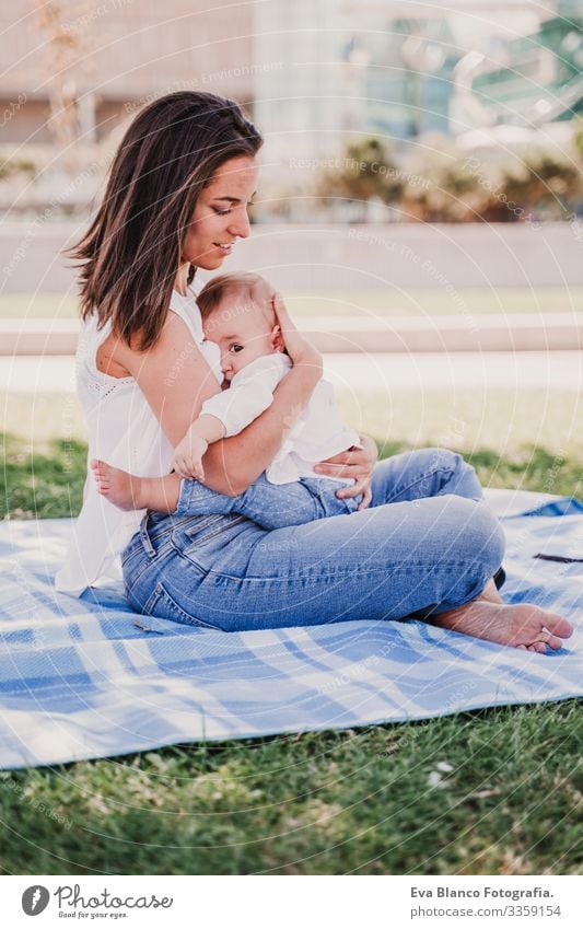 junge Mutter, die im Park im Freien ihr Baby stillt, glückliches Familienkonzept. liebe Mutter-Tochter stillen Milch Essen Kind Kindererziehung Mädchen Freude