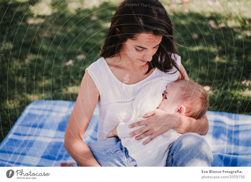 junge Mutter, die im Park im Freien ihr Baby stillt, glückliches Familienkonzept. liebe Mutter-Tochter stillen Milch Essen Kind Kindererziehung Mädchen Freude