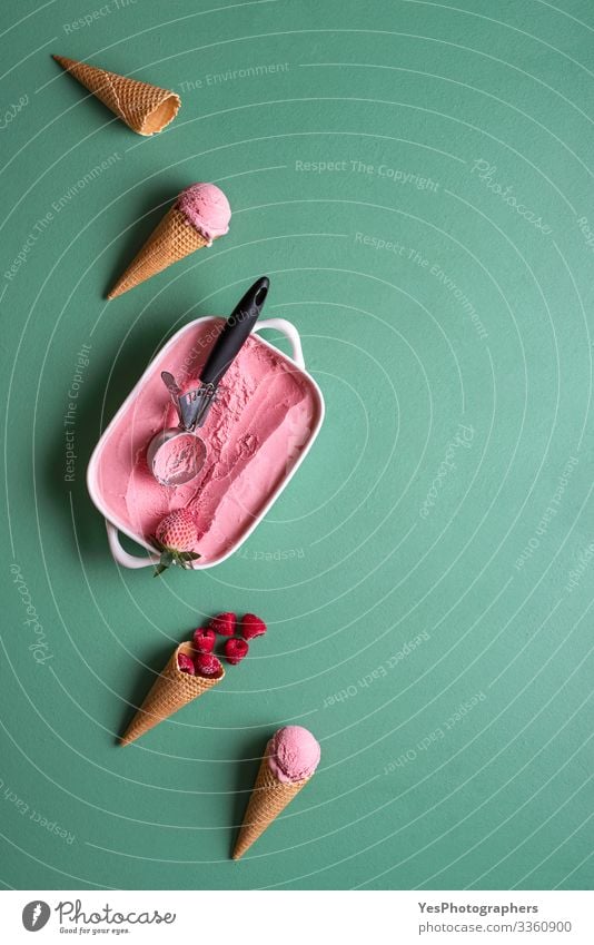 Himbeereis und Waffelzapfen auf grünem Tisch Lebensmittel Milcherzeugnisse Frucht Dessert Speiseeis Geschirr Pfanne Coolness frisch lecker obere Ansicht