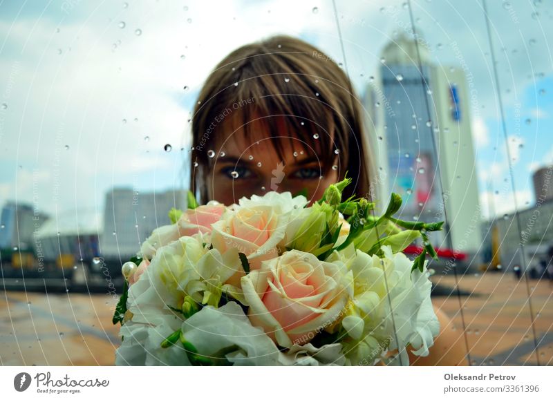 Das Mädchen hält einen Blumenstrauß hinter dem Glas schön Dekoration & Verzierung Feste & Feiern Hochzeit Frau Erwachsene Kultur Natur Regen grün Tradition