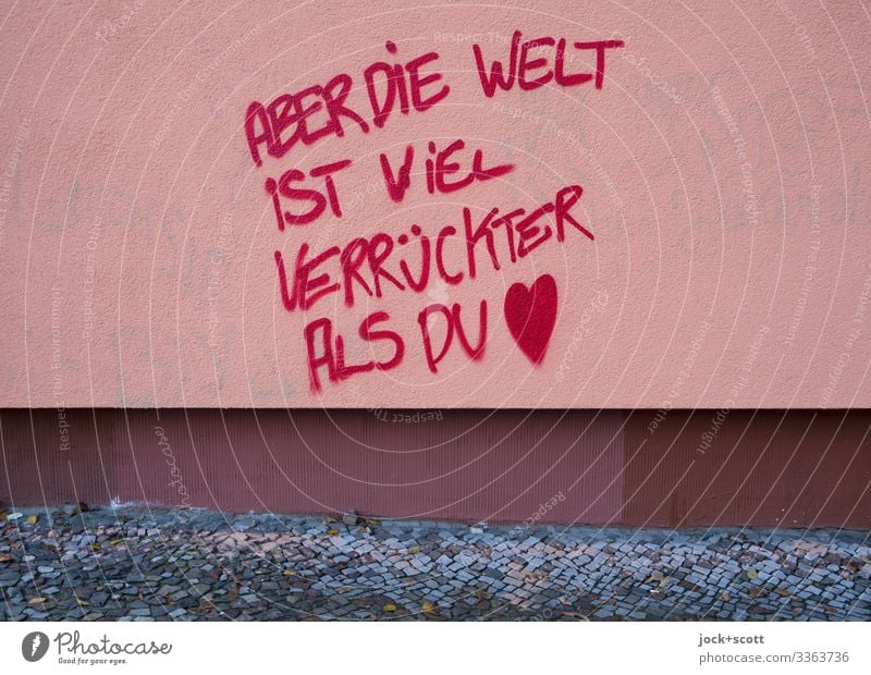 Verrückte Welt geschrieben auf einer tristen Hauswand Straßenkunst Wand Fassade Bürgersteig Schriftzeichen Denken verrückt rot selbstbewußt Weisheit