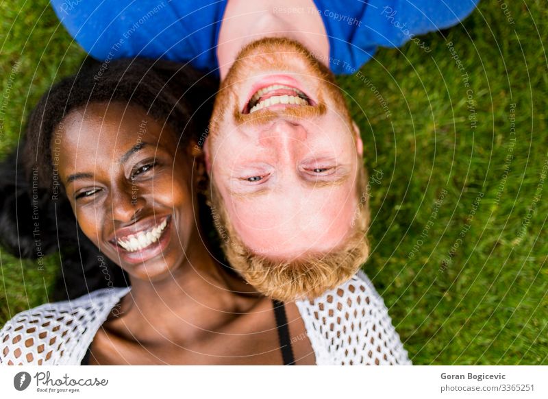 Mehrrassiges Paar im Park Lifestyle Sommer Mensch Junge Frau Jugendliche Junger Mann Erwachsene 2 18-30 Jahre Gras rothaarig Zusammensein modern Freund lässig