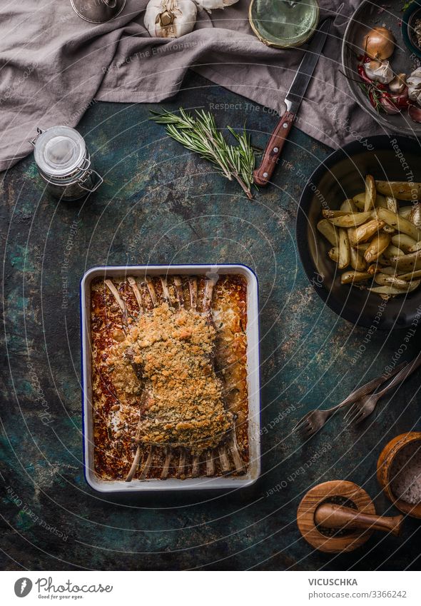 Gebratene Lammkarrees mit Kruste auf dunklem, rustikalem Tisch, Draufsicht. Fleischnahrung oben Barbecue grillen Knochen hacken gekocht Essen zubereiten