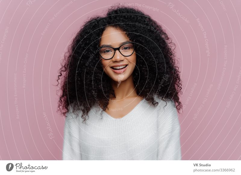 Angenehm lächelnde Frau, trägt eine optische Brille Freude Glück Haare & Frisuren Schminke Zufriedenheit Mensch Erwachsene Bekleidung Pullover Afro-Look Lächeln