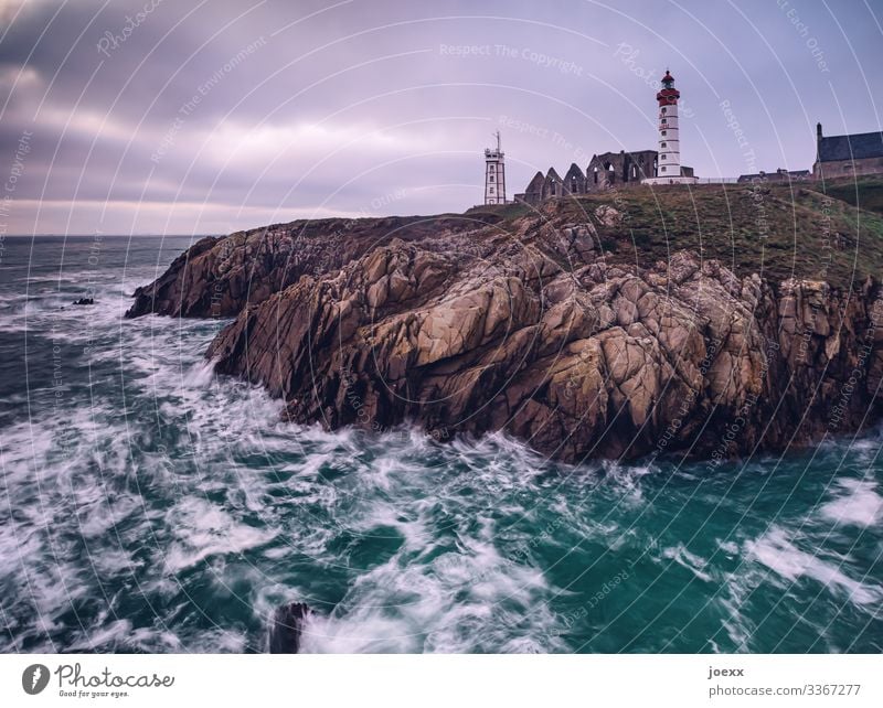 Leuchtturm an Bretonischer Felsküste mit Wellen und Meer Weitwinkel Außenaufnahme Farbfoto Idylle Horizont Hoffnung Fernweh Heimweh ruhig weiß braun blau