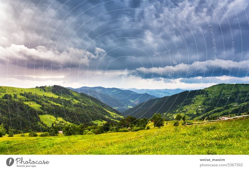 Sommerregen im Bergtal Regen Berge Unwetter Wolken bedeckt Dorf ländlich Wiese Tag Ökologie Hügel Tal Hütte Haus dramatisch Straße malerisch Licht Landschaft