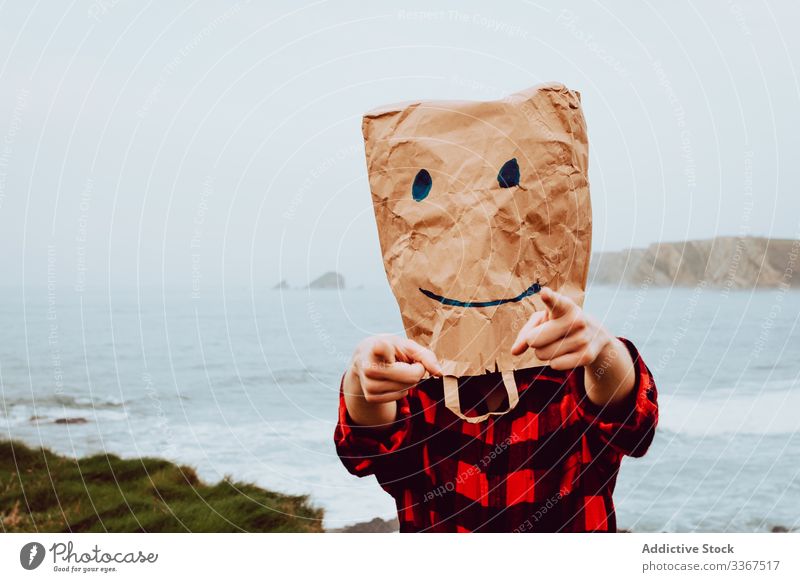 Person mit Papiertüte am Kopf, die auf die Kamera zeigt Kunststoff Paket Ökologie Tüte Konzept Zeigen Umwelt gestikulieren Zeichen Natur Verschmutzung Tasche