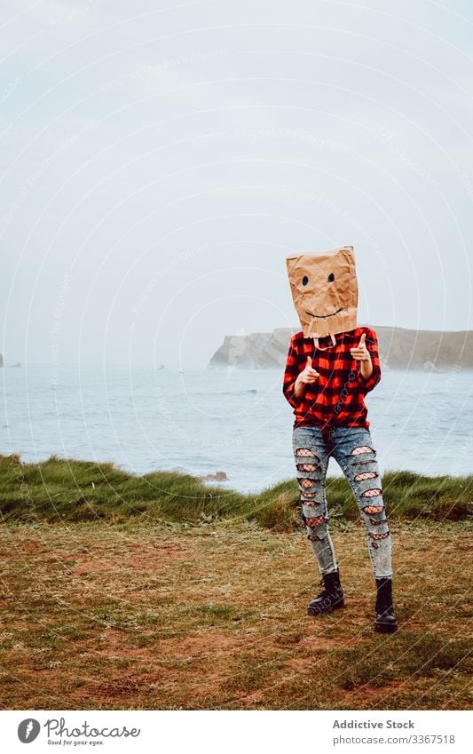 Person mit Papiertüte am Kopf, die auf die Kamera zeigt Kunststoff Paket Ökologie Tüte Konzept Zeigen Umwelt gestikulieren Zeichen Natur Verschmutzung Tasche