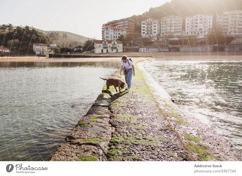 Frau mit Hund beim Spaziergang auf dem Steinpier Pier Gebäude Wasser MEER Zusammensein Haustier Küste Tier Lifestyle jung lässig Freundschaft Spanien lekeitio