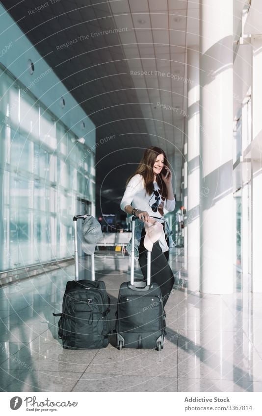 Ruhige Frau telefoniert am Flughafen sprechend Telefon Surfen benutzend Gepäck Urlaub Abheben Ankunft Abenteuer Tasche warten Smartphone Verzögerung Öffentlich