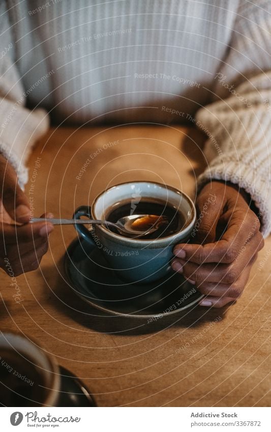 Anonyme Frau mit Kaffeetasse im Café Tasse Hand Erwachsener Person Sitzen genießend frisch heiß gebraut Becher trinken Getränk schwarz Tisch hölzern Kantine