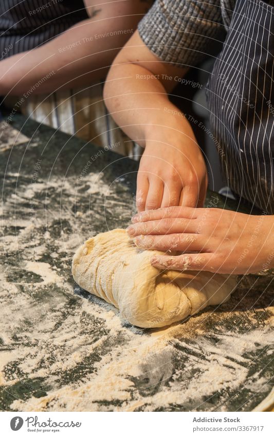 Erntemann, der auf bemehltem Tisch Teig knetet Frau kneten Teigwaren Mehl Brot Bäcker Lebensmittel Brötchen Schürze Küche Mahlzeit Müsli handgefertigt Rezept